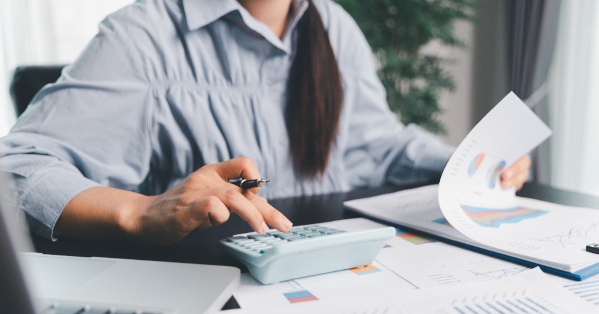 Un economist în timp ce calculează ce taxe are de plătit și își achită facturile pentru afacerea lui