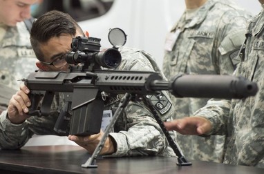 A US Army soldier looks over a Barrett M107A1 rifle, which is designed to be used with a suppressor, during the Association of the United States Army Annual Meeting and Exposition in Washington, DC, October 13, 2014. Headquartered in Murfreesboro, Tennessee, Barrett is a large-caliber rifle design and manufacturing company.,Image: 208072774, License: Rights-managed, Restrictions: , Model Release: no