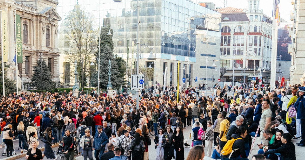 În imagine sunt ilustrați oameni care se află pe o șosea care a devenit pietonală