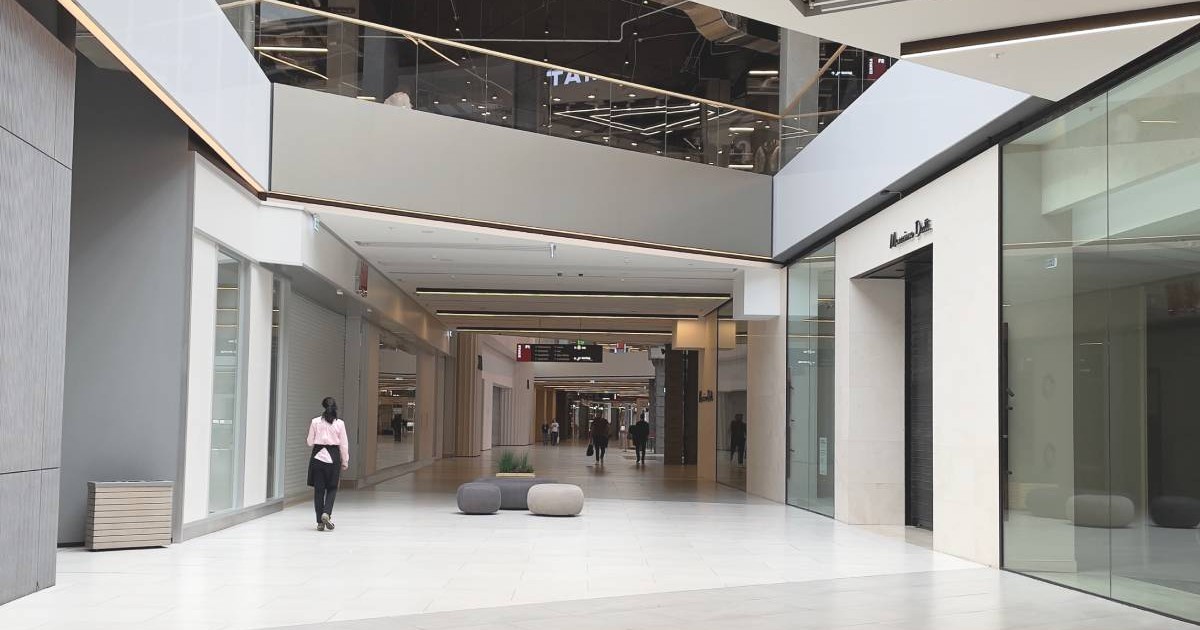 Coridorul unui centru comercial din Rusia, unde se vede ca magazinele de haine sunt goale și închise