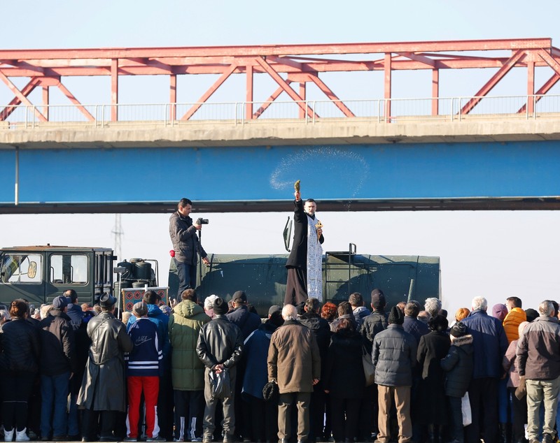 FOTO| La Buzău, un preot militar a binecuvântat multimea cocoțat pe o cisternă a Armatei, de sub podul de la Mărăcineni