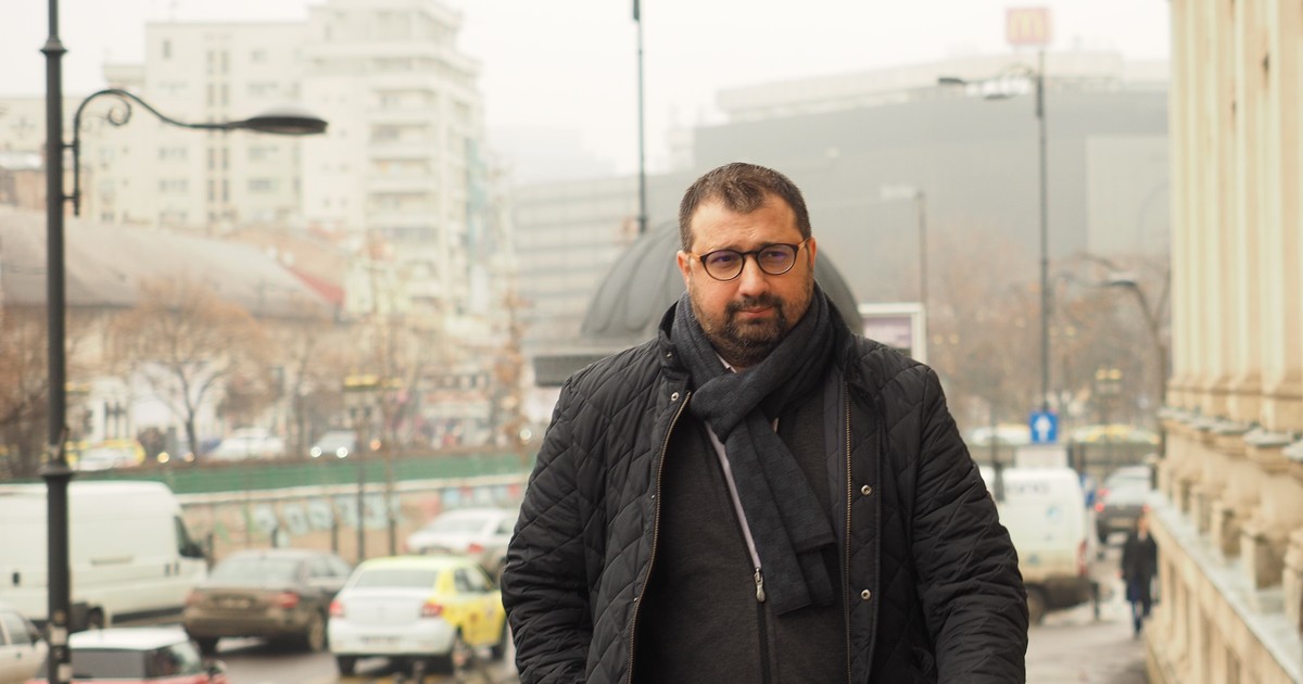 Un barbat imbracat in negru merge pe strada