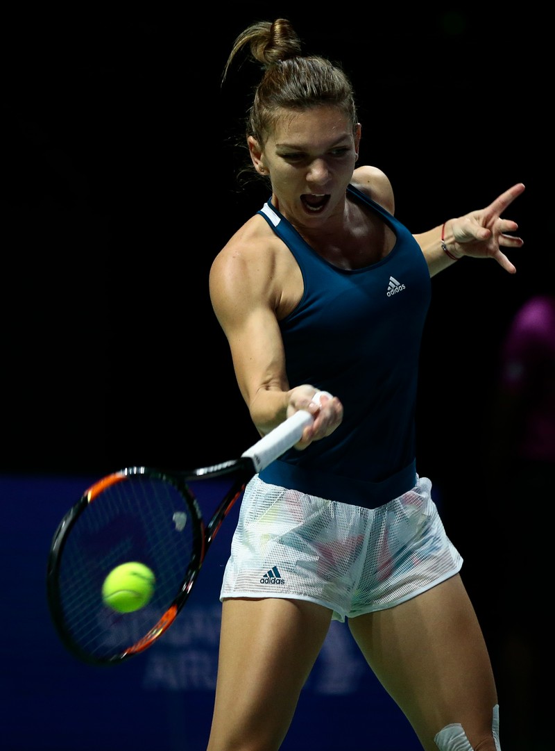 epa05605186 Simona Halep of Romania in action against Dominika Cibulkova of Slovakia during their singles round robin match of the BNP Paribas WTA Finals 2016 held at the Indoor Stadium in Singapore, 27 October 2016. EPA/WALLACE WOON
