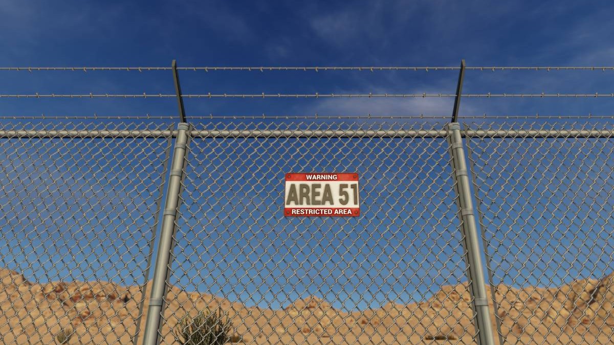 Un afiș cu Area 51 așezat pe un gard din sârmă în deșertul Nevada din SUA.