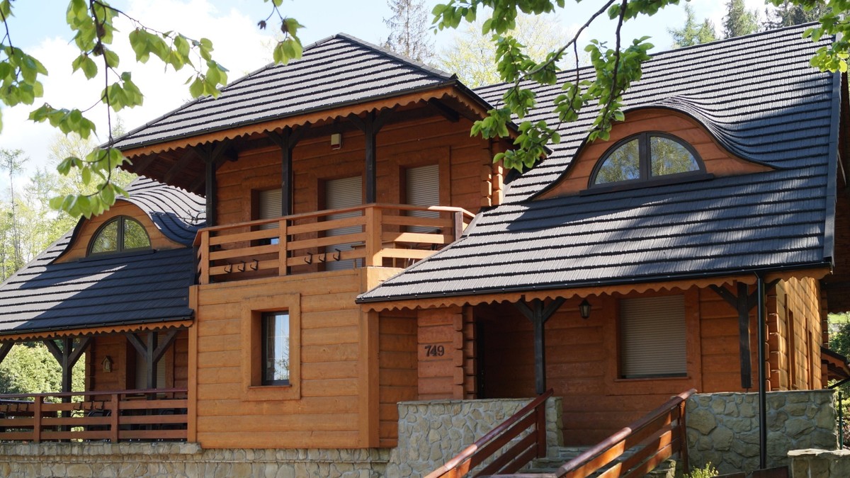 Cabana de munte din lemn cu acoperis gri inchis din roca vulcanica