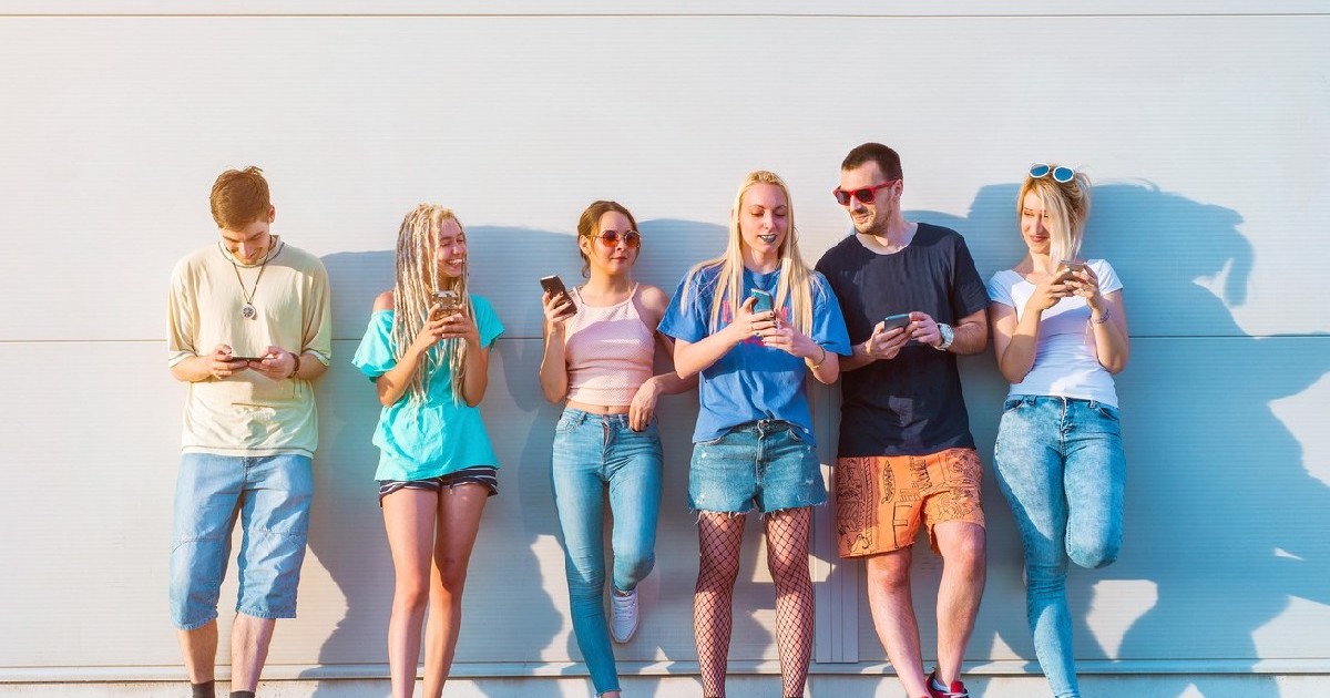 Grup de tineri care își folosesc telefoanele mobile