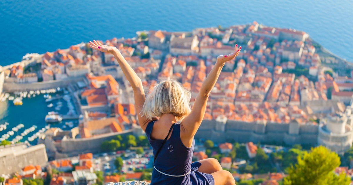 Care sunt cele mai însorite oraşe din Europa - Imagine cu o tânără care priveşte de pe munte asupra oraşului vechi din Dubrovnik