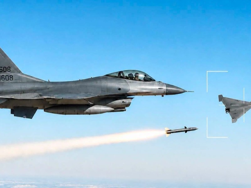 Imaginea ilustrează un avion de vânătoare F-16 al Forțelor Aeriene Române lansând o rachetă asupra unei drone militare încadrate în vizor pe cerul senin.