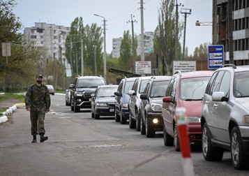 Un militar transnistrean trece pe lângă o linie de mașini aflate la coadă pentru a ieși din autoproclamata Republică Moldovenească Transnistria, la punctul de frontieră Varnița cu Republica Moldova pe 28 aprilie 2022. Rusia, pe 28 aprilie 2022, a tras un semnal de alarmă cu privire la „acte de terorism” în regiunea separatistă a Moldovei, susținută de Moscova, Transnistria, după ce autoritățile separatiste au raportat mai multe atacuri acolo în această săptămână. Temerile de destabilizare în regiune au crescut după ce un general rus a declarat că ofensiva Kremlinului are ca scop crearea unui coridor de uscat prin sudul Ucrainei până în Transnistria. Foto: Profimedia