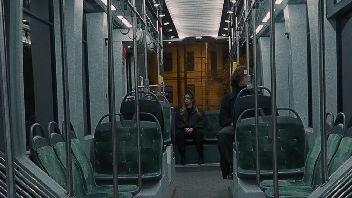 Un tânăr și o tânără într-un mijloc de transport în comun