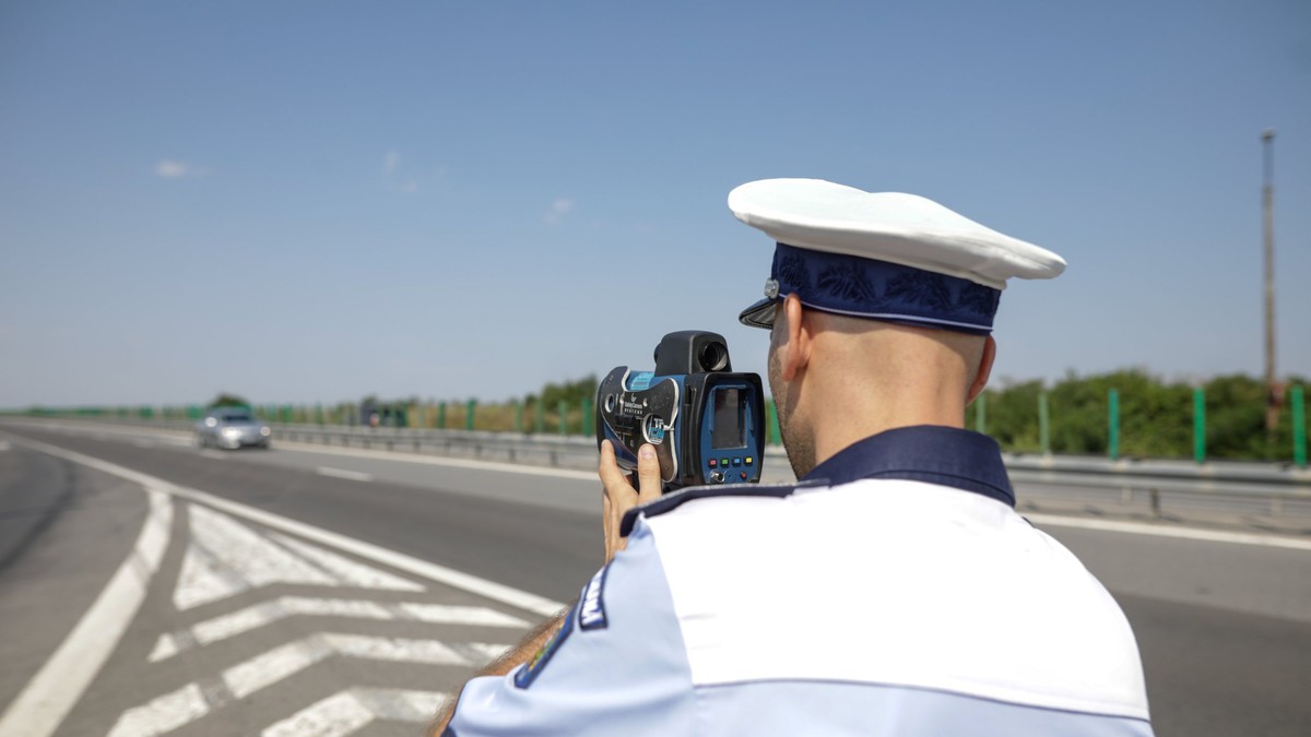 Codul Rutier 2022 – care sunt noile limite de viteză și ce sancțiuni riști dacă le încalci - Poliţist care măsoarea viteza autovehiculelor cu radarul pe o autostradă