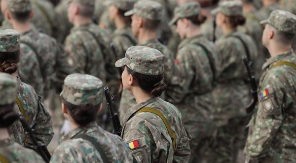 Militari români, femei și bărbați, îmbrăcați în uniforme militare