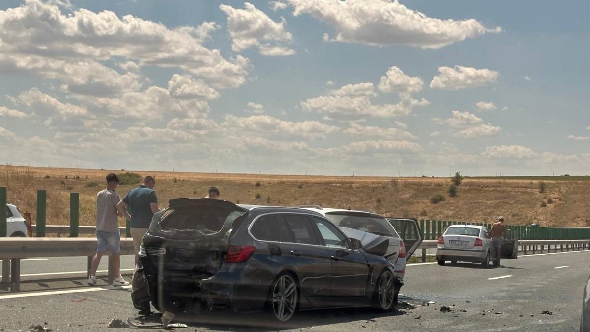 Imagine cu un BMW negru implicat în accidentul de pe A2 din 20 iulie 2025. Lângă vehicul se află trei bărbați, iar mai în față se află o altă mașină gri