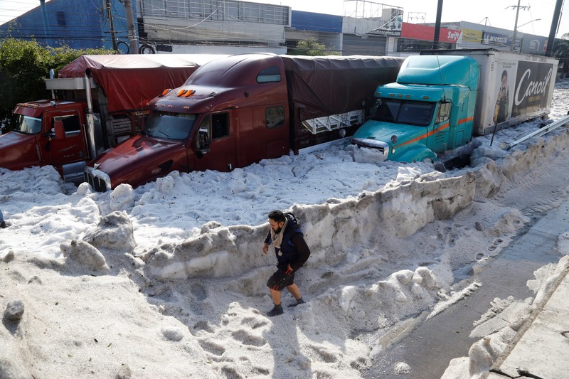 Un bărbat mergând pe străzile din Guadalajara, Jalisco, Mexico. În unele cazuri, gheața a intrat în case prin rețeaua de canalizare. EPA-EFE/Francisco Guasco