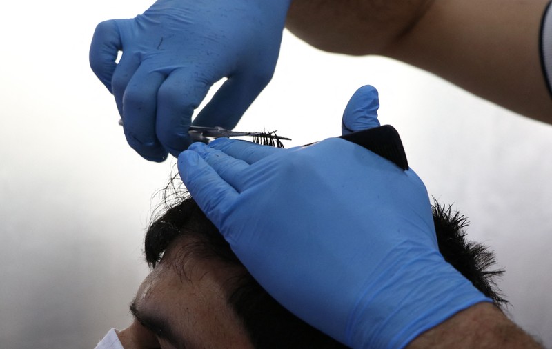 Două măști pierdute în starea de alertă. Scenetă mută dintr-un salon de frizerie