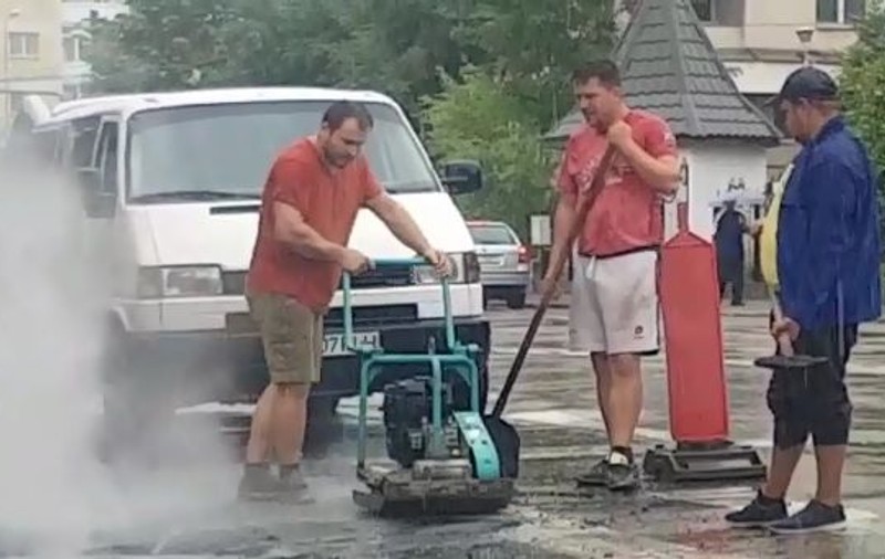 Gropi reparate pe ploaie în Câmpina. Explicația muncitorilor: „Mai fac treaba o dată, că dacă m-a prins ploaia” / VIDEO
