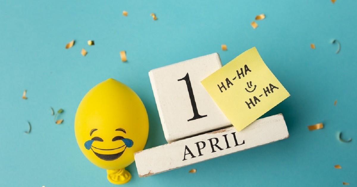 Data de 1 aprilie scrisa pe fundal bleu, lângă un balon galben cu emoticon amuzant si un bilețel pe care scrie Ha-ha