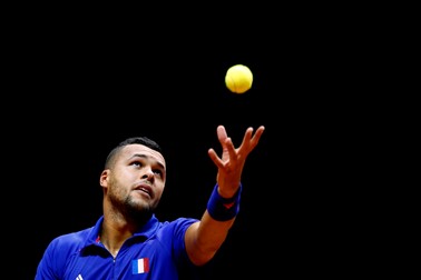 epa04498282 Jo-Wilfried Tsonga of France serves the ball to Stanislas Wawrinka of Switzerland during their singles match on the first day of the Davis Cup World Group Final between France and Switzerland at the Pierre Mauroy Stadium in Lille, France, 21 November 2014. EPA/YOAN VALAT