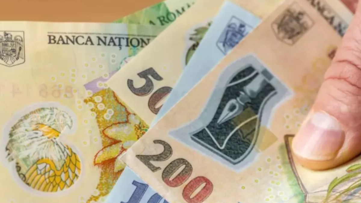 O persoană care ține în mână bancnote în lei