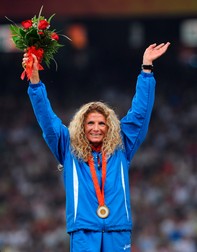 epa01452350 Romania's Constantina Tomescu celebrates on the podium with her gold medal after winning the women's Marathon at the Beijing 2008 Olympics in Beijing, China, 17 August 2008. EPA/Gero Breloer