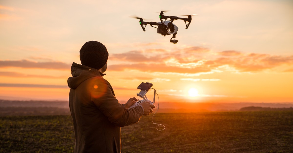 Noi reglementări privind folosirea dronelor, valabile din 2023 - Un bărbat care operează o dronă pentru a filma un apus de soare