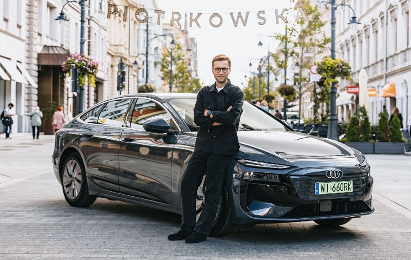 Pilotul Miko Marczyk lângă un Audi A6 electric, negru