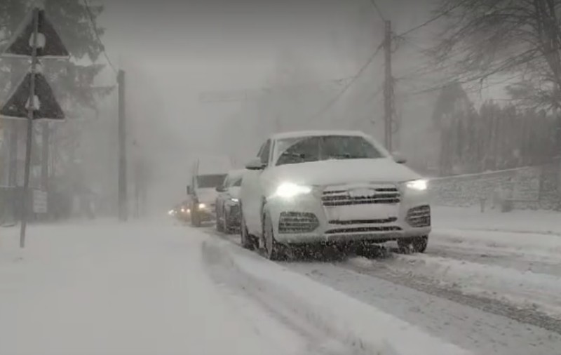 Trafic rutier în condiţii de iarnă pe Valea Prahovei. Ninge viscolit și drumul e acoperit cu zăpadă între Sinaia şi Predeal