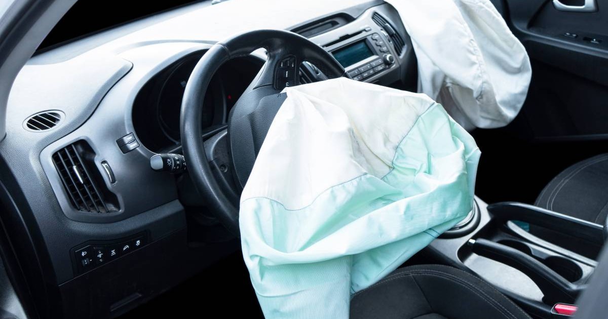 interiorul unei masini in care se vede bordul si airbag-ul sarit in urma unui accident