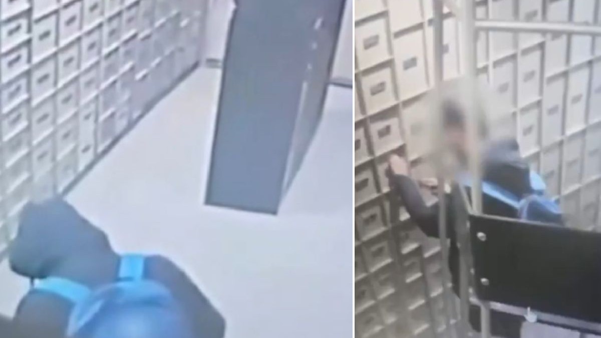 O cameră de supraveghere surprinde o persoană îmbrăcată cu o haină neagră și purtând un rucsac albastru în interiorul unei camere cu rafturi metalice.