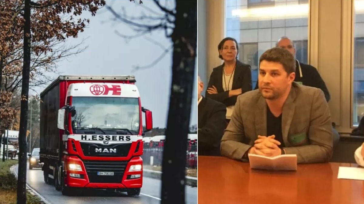 Un bărbat cu mâinile pe o masă, în dreapta, și un camion cu cabină vopsită roșu și alb, în stânga