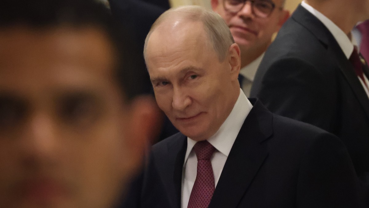 Vladimir Putin, în timpul unui eveniment oficial. Este înconjurat de oameni și poartă un costum albastru