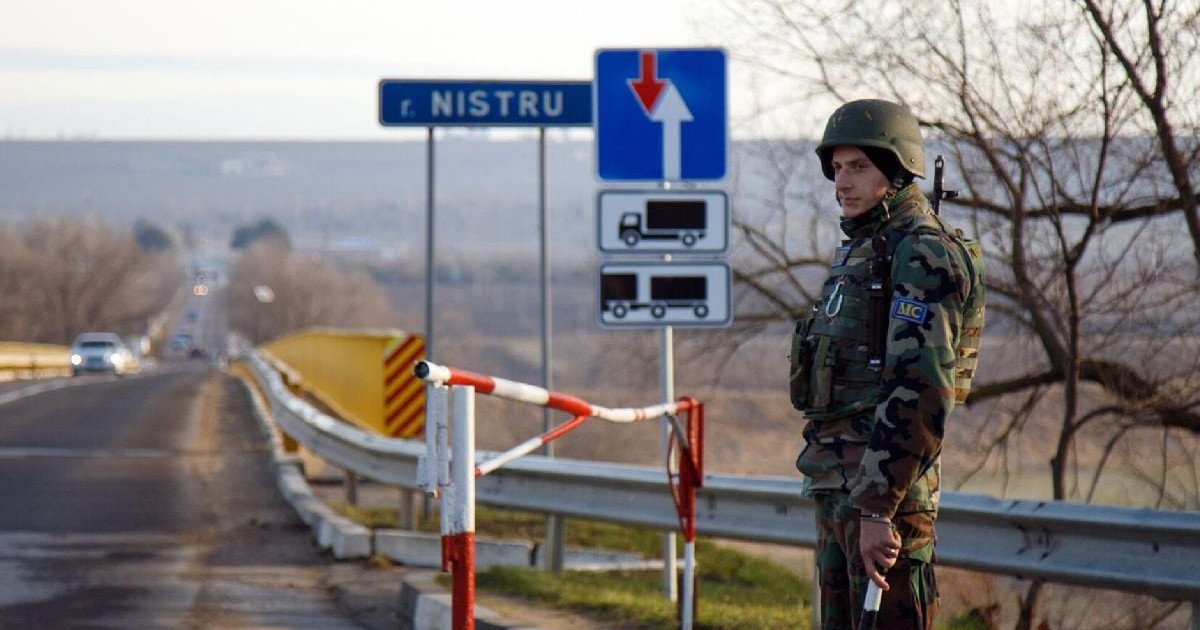 Un soldat cu cască și pușcă pe marginea unei șosele, în Transnistria, la grnaița cu Republica Moldova