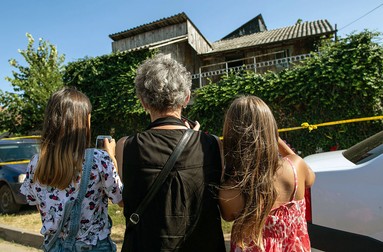 O bunica și nepoatele ei fotografiază cu telefoanele mobile casa lui Gh. Dincă