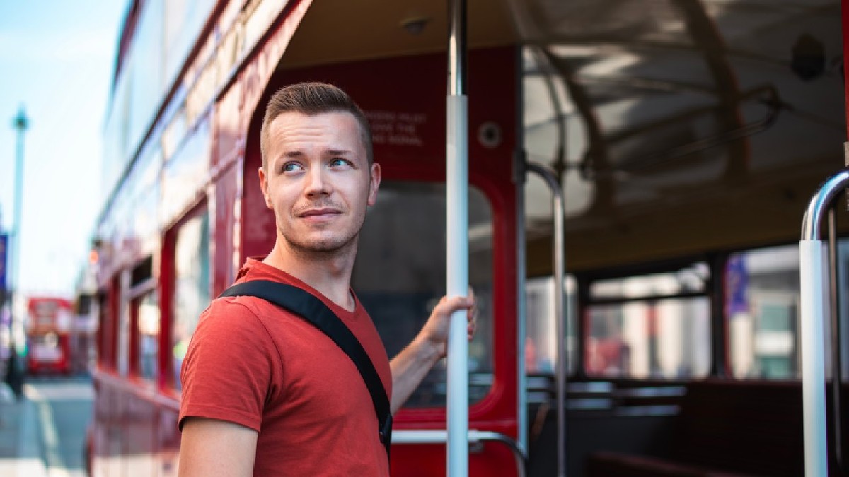 Portretul unui turist urcând într-un autobuz roșu cu două etaje în centrul Londrei, Regatul Unit.