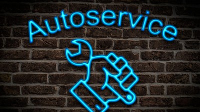 Leuchtreklame für Autoservice, ein Maulschlüssel wird in der Hand gehalten | Illuminated advertisement for car service, a spanner is held in the hand