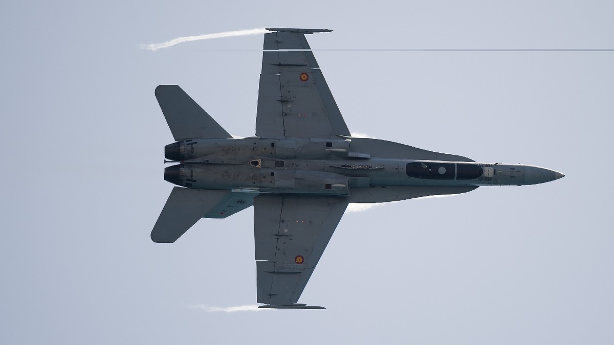 Un avion de vânătoare F-18 efectuează o demonstrație aeriană în cadrul Spectacolului Aerian Internațional Torre del Mar 2024, pe plajă.