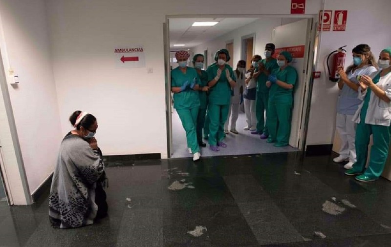 Fotografia anului în Navarra, Spania. Mamă româncă, în genunchi în fața medicilor care i-au salvat fiul bolnav de COVID