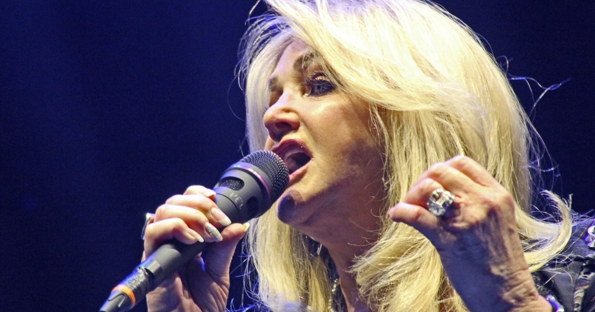 Bonnie Tyler în timp ce cântă la microfon