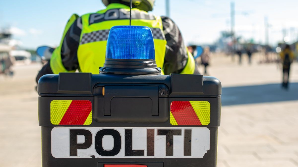 Un polițist aflat pe o motocicletă are vestă reflectorizantă, iar în prim-plan se vede sirena albastră, în Norvegia