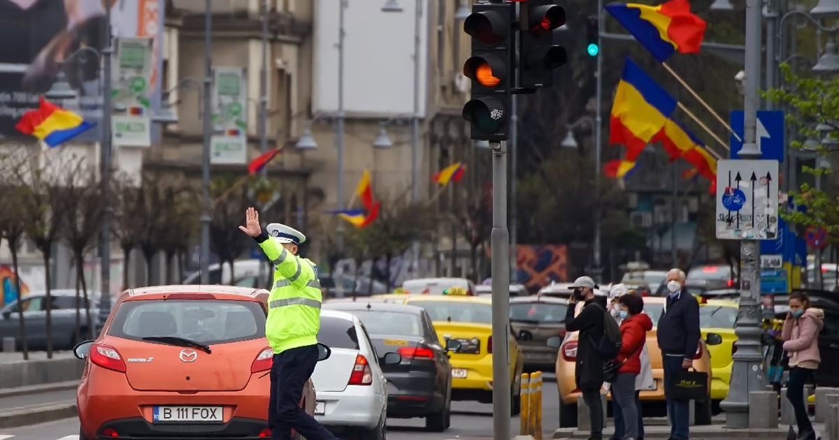 București, România – 28 aprilie 2021: Un polițist dirijează traficul la o intersecție din București.