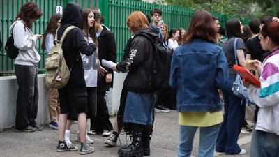 elevi de clasa a 12-a in fata intrarii unui liceu, inainte de proba la bac