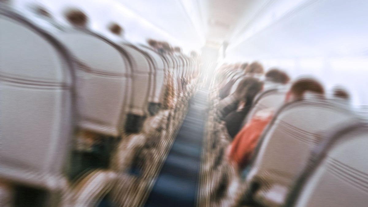 Avion care se zguduie în timpul turbulențelor, trecând printr-un gol de aer. Imagine neclară cu un avion comercial care se deplasează rapid în jos.
