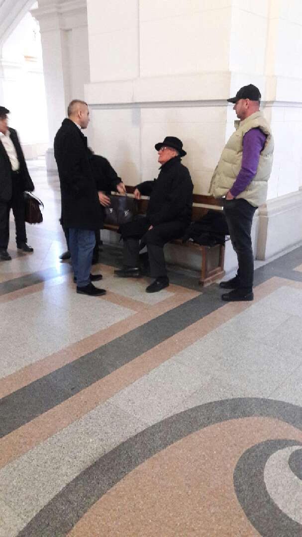Dumitru Dragomir stă pe o bancă pe holurile Curții de Apel București, în așteptarea începerii unui nou termen în dosarul dezafilierii Universității Craiova. (FOTO: Daniel Conțescu)