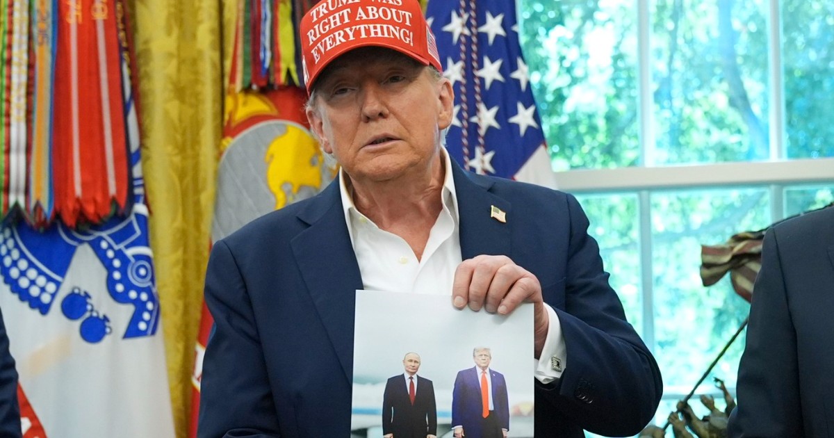 Președintele Donald Trump ține o fotografie cu el și președintele rus Vladimir Putin în timpul unei declarații în Biroul Oval al Casei Albe, vineri, 22 august 2025, la Washington.