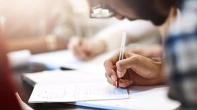 Elev scriind în timpul examenului