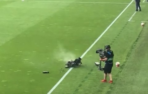 O cameră suspendată a luat foc și s-a prăbușit pe teren în timpul unui meci de fotbal, fiind aproape să lovească un cameraman