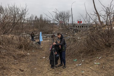 Oamenii din Irpin trec peste un pod distrus pentru a părăsi orașul | Foto: EPA