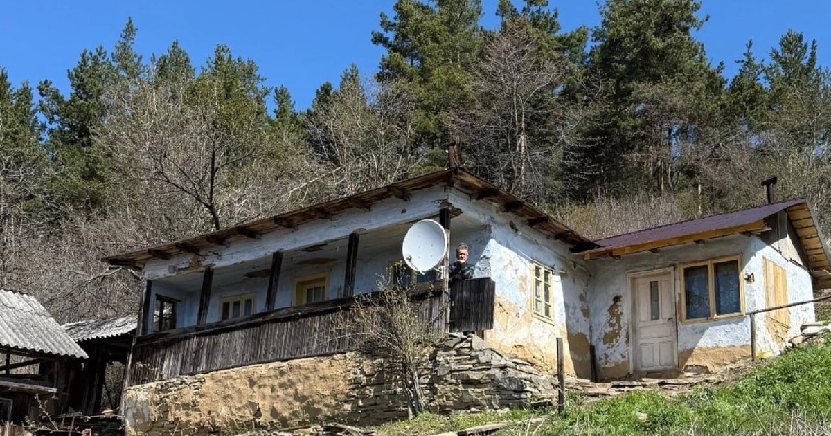 Un bărbat stă pe prispa unei case dintr-un sat izolat din Buzau