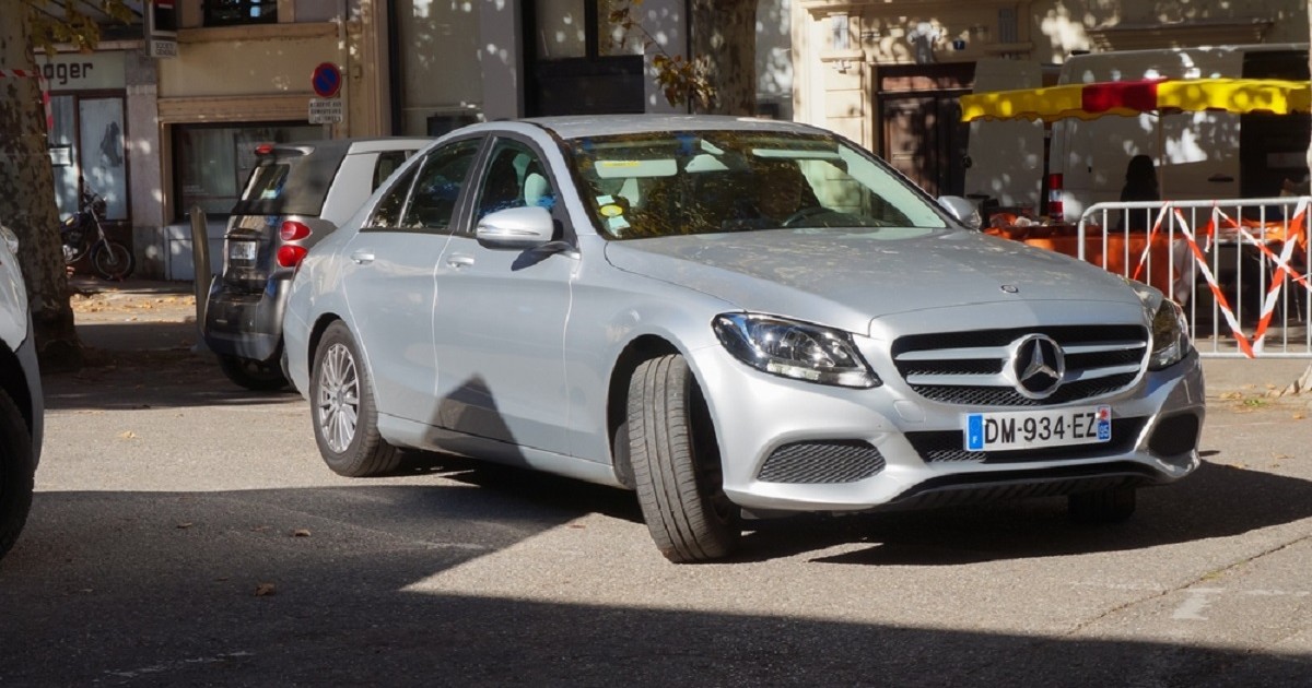 O mașină argintie, marca Mercedes, parcată cu roțile din față virate