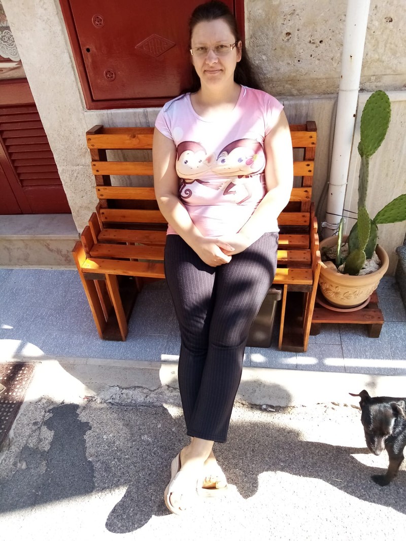 Angela, într-o mică pauză de la treburi, în fața casei sale
